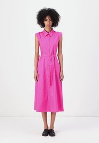 Mouwloze roze knoop-jurk met een getailleerde taille en bijpassende riem, met een knie-lange A-lijn rok en minimalistische ontwerpdetails.