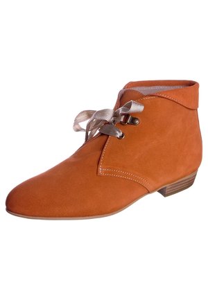 Bota de tobillo de ante color óxido con cordones de cinta beige, detalle de costuras y tacón bajo de madera apilada.