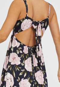 Sukienka w kwiaty na granatowym tle, z dużymi różowymi kwiatami, z dekoltem w serek z tyłu oraz wiązaniem z tyłu. Wykonana z miękkiego materiału.