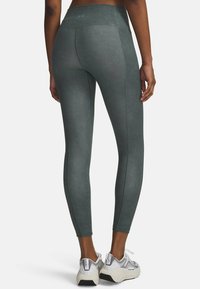High-waisted, dark teal leggings made from soft, stretchy material with subtle texture, featuring contrasting stitching and a sleek fit.