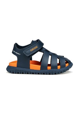 Sandale enfant bleu marine avec brides fermées à l'avant, semelle intérieure rembourrée orange, bride Velcro ajustable et semelle robuste pour une utilisation extérieure.