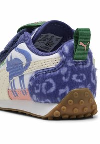 PUMA superge z teksturirano vijolično umetno krzno na peti, bel sintetičen zgornji del, roza in modri detajli ter Velcro zapiranje.