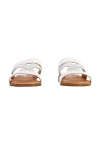 Weiße Leder-Sandalen mit drei übereinanderliegenden Riemen, einer flachen braunen Sohle und einer glatten, matten Textur.