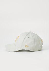 Light gray cap with a structured shape, featuring yellow embroidery of a logo and the word "You." Includes vent holes and a curved brim.