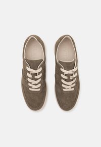 Brune semskede sneakers med perforert tekstur, lysebeige snøringer og et minimalistisk design. Har preget logo på innsiden av sålen.