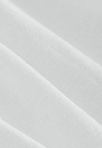 Biely textil zobrazený vo záhyboch, s jemnou, hladkou textúrou a miernym leskom. Materiál sa zdá byť ľahký a jednotný.