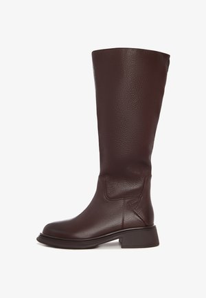 Botte en cuir marron jusqu'au genou avec une finition légèrement texturée, dotée d'un talon épais et d'un minimum de coutures sur le côté.