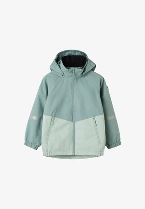 Veste imperméable vert clair avec fermeture éclair à l'avant, capuche, poignets élastiques et deux poches zippées ; présente des panneaux contrastants en vert plus clair.