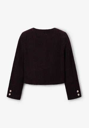 Veste courte de couleur violet foncé avec un tissu texturé, un large décolleté et des manches longues ornées de boutons dorés aux poignets.