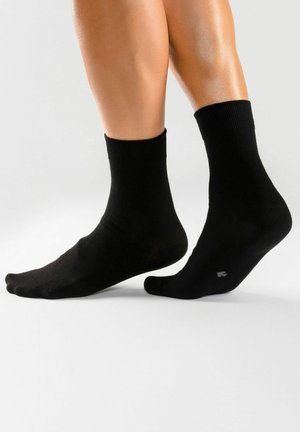 Schwarze Knöchelsocken mit gerippten Bündchen, aus einem glatten Material, mit minimalistischem Design und ohne sichtbare Muster oder Akzente.