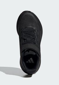 Chaussure de sport noire avec tige texturée, col rembourré et lacets. Comprend un détail de logo sur la languette et une semelle en caoutchouc.