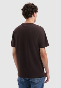 Bruine short-sleeve t-shirt met een ronde hals. Zacht katoen, ontspannen pasvorm, gladde textuur, met een klein logo detail op de achterkant.