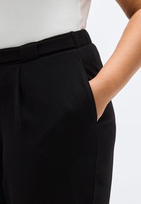 Μαύρο ραμμένο παντελόνι με λεία υφή, διαθέτει άνετη μέση και λεπτομέρεια πλαϊνής τσέπης. Κατάλληλο για διάφορες περιστάσεις.