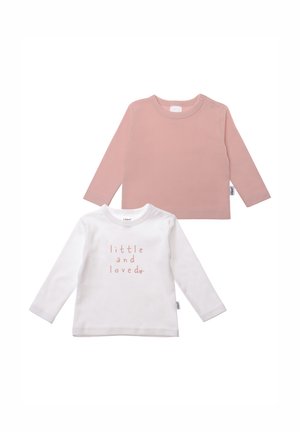 Two long-sleeve shirts: one in soft pink, the other in white with pink printed text "little and loved," crafted from cotton.