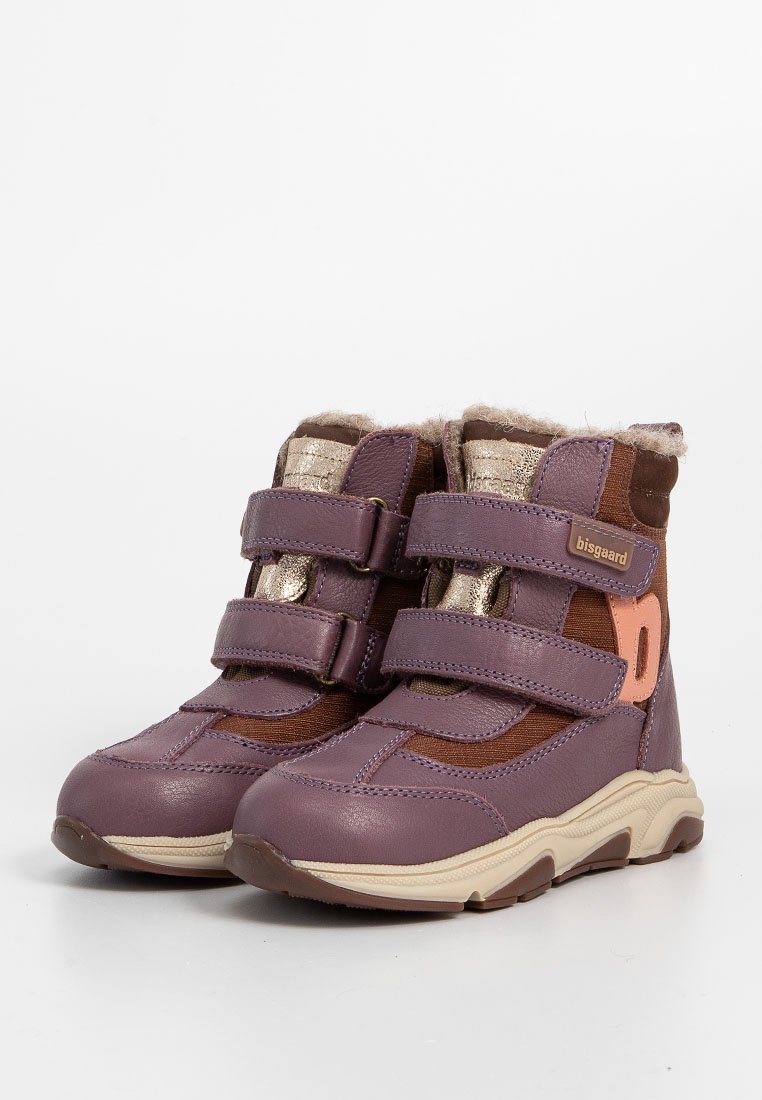 Lila und braune Stiefeletten mit zwei Klettverschlüssen, beiger Laufsohle, goldenen Akzenten und einem plüschigen Futter am oberen Rand. Strapazierfähiges strukturiertes Material.