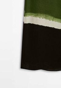 Multicolor stof met groen aan de bovenkant, een witte streep en zwart aan de onderkant, met een gladde textuur en een zachte val.