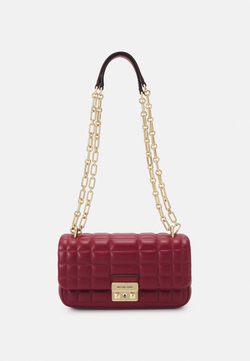 Sac à épaule en cuir bordeaux matelassé avec bandoulière chaîne dorée et fermoir rectangulaire doré gravé du nom de la marque.
