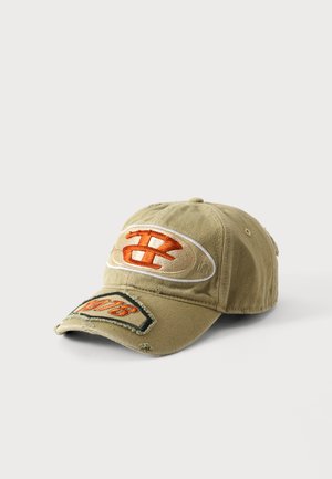 Beige distressed baseballkasket med orange broderet logo og et mærke på kasketkanten mod en ensfarvet hvid baggrund.