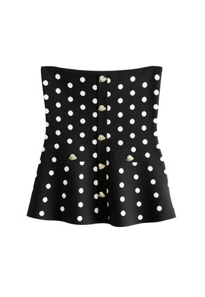 Top bustier noir à basque avec des pois blancs, boutons décoratifs argentés en forme de coquillage au centre et sur deux poches avant à rabat.