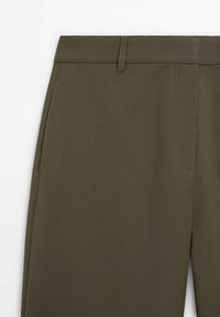 Pantalons vert olive en tissu lisse, avec une taille plate, des passants de ceinture et une poche latérale unique pour une touche supplémentaire.