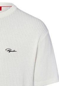 Weißes, geripptes Strick-T-Shirt mit rundem Halsausschnitt und kurzen Ärmeln, das ein schwarzes gesticktes Logo auf der Brust zeigt.
