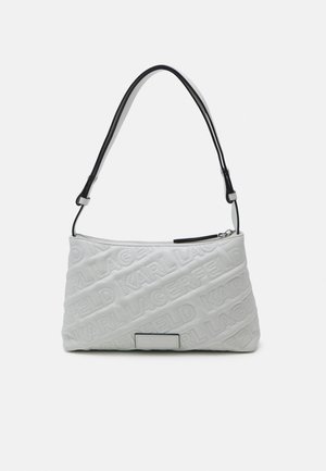 Sac à main rectangulaire blanc avec texte en relief "KARL LAGERFELD" et bandoulière noire réglable, fermeture éclair en haut.
