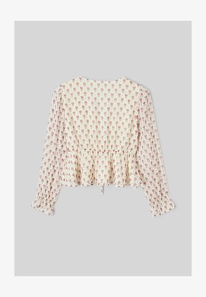 Blouse de couleur crème à motif floral, manches longues, taille cintrée et ourlet à volant. Le matériau semble léger et texturé.
