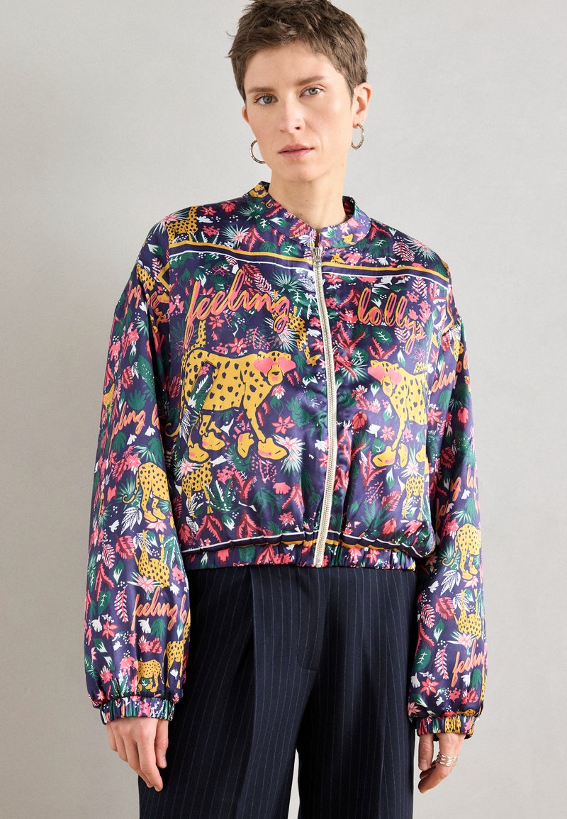 Veste bomber colorée avec un design floral et imprimé léopard dans des tons de vert, rose et jaune ; fermeture éclair et poignets élastiques.