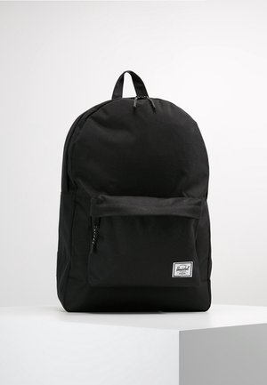 Czarny plecak Herschel z przednią kieszenią na zamek i górnym uchwytem, prezentowany na białym postumencie na jednolitym białym tle.