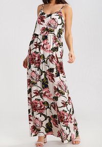 Maxiklänning med blommönster i rosa och grönt på vit bakgrund. Tunna axelremmar, lös passform och lättviktigt tyg med lagerdesign.