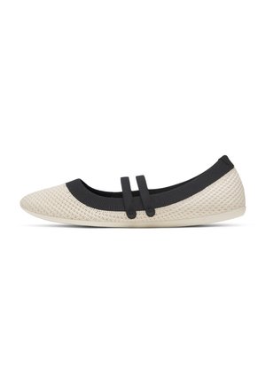 Scarpa piatta beige intrecciata con rifiniture nere e due cinturini elastici neri sulla parte superiore, punta tonda e suola flessibile.