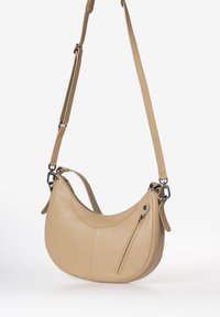 Beige leren schoudertas met een gebogen silhouet, verstelbare schouderriem, ritsvak en een gladde textuur. Voorzien van metalen accenten.