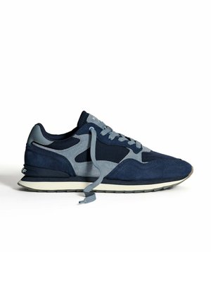 Navy and gray suede and fabric sneaker with white sole and loosely tied gray shoelace on plain white background.