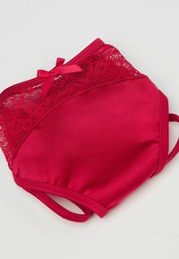 Czerwony komplet bielizny wykonany z gładkiej tkaniny, z koronkową lamówką u góry i kokardką jako ozdobą. Z regulowanymi ramiączkami i wygodnym dopasowaniem.