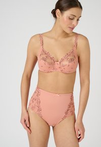 Set di reggiseno rosa chiaro e mutandine a vita alta, con ricami floreali dai colori contrastanti, texture liscia e fiocchi decorativi.