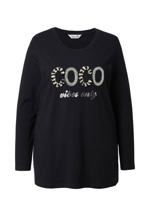 Camiseta negra de algodón de manga larga con "COCO" texturizado en adornos plateados y crema, con "vibes only" en una fuente metálica.