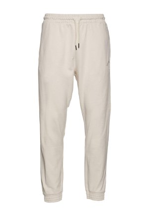 Krémové tepláky vyrobené z mäkkého materiálu, s elastickým pásom na šnúrku, priliehavými manžetami a jemným logom.