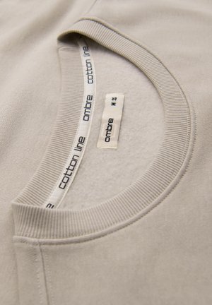 Lichtbeige katoen sweatshirt met een ronde hals. Kenmerkt zich door een geribde kraag en een label aan de binnenkant met "ombre" en "katoenlijn" branding.