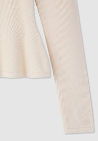 Maglione crema a coste con maniche lunghe, caratterizzato da un orlo leggermente svasato e una finitura testurizzata. Design semplice e minimalista senza decorazioni.