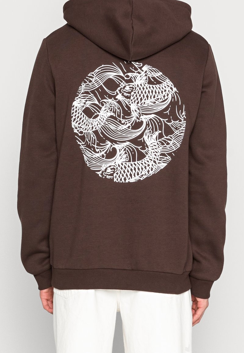 Bruine hoodie met een witte grafiek van draaiende vissen op de achterkant. Gemaakt van zachte stof met een trekkoordkap en geribbelde onderrand.