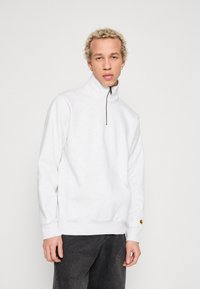 Lysegrå quarter-zip sweatshirt lavet af blødt stof, med en kængurulomme og en gylden logoaccent på venstre ærme.