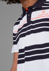 Polo à rayures en bleu marine et blanc, avec des accents orange et un col. Le texte indique "FIRE + ICE" sur le devant.