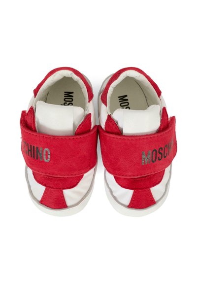 Czerwono-białe trampki dla malucha wykonane z zamszu i materiałów syntetycznych, z rzepem i logo "MOSCHINO" w kolorze srebrnym na pasku.