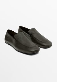 Černé kožené mokasíny s hladkým povrchem, špičatou špičkou a minimalistickým designem. Detaily prošití podél horní části.