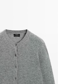 Cardigan in cashmere grigio chiaro con collo rotondo e cinque bottoni scuri lungo il davanti, posato su uno sfondo bianco.