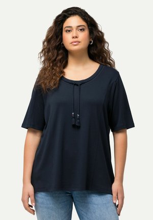 Top de manga corta azul marino con cuello redondo, que presenta un diseño con cordón en la parte delantera y borlas decorativas. Fabricado en una tela suave y lisa.