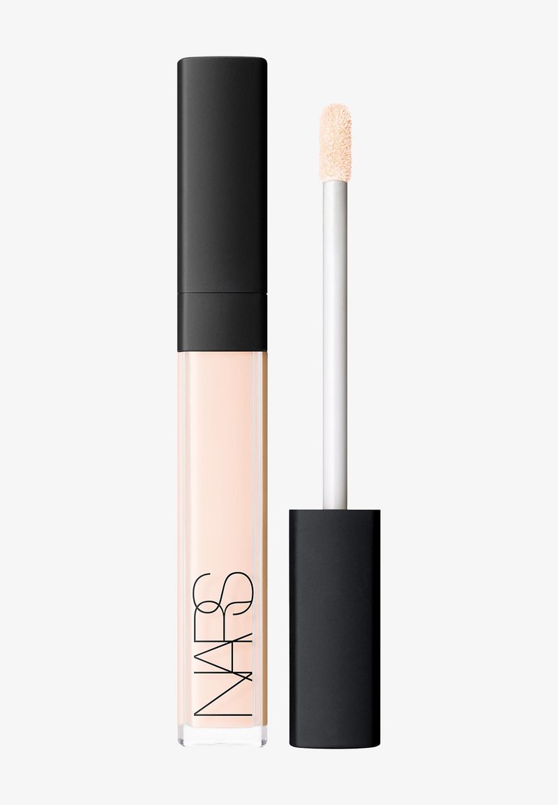 Corrector líquido de NARS en un tubo traslúcido con tapa negra. Presenta una punta de aplicador suave, el tono del producto es beige pálido.