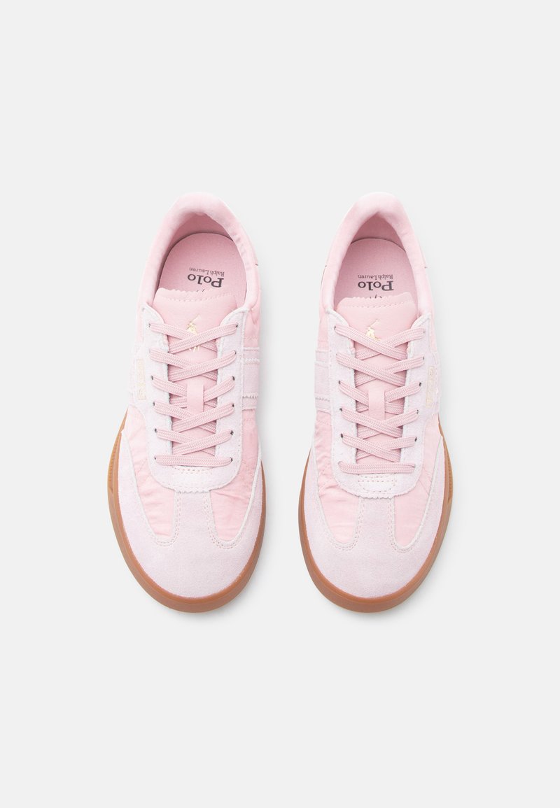 Paire de baskets basses roses avec semelles en caoutchouc couleur gomme, dessus en tissu et daim, et lacets, vues de dessus sur un fond blanc.