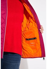 Chaqueta acolchada morada con forro naranja, que cuenta con un cierre de cremallera, un bolsillo interior y un dobladillo acanalado. El material exterior tiene una textura suave.