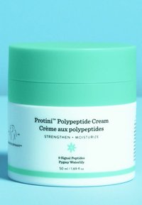 Green and white jar of Protini Polypeptide Cream, labeled with text. The lid is a vibrant mint green, and the jar has a smooth texture.
